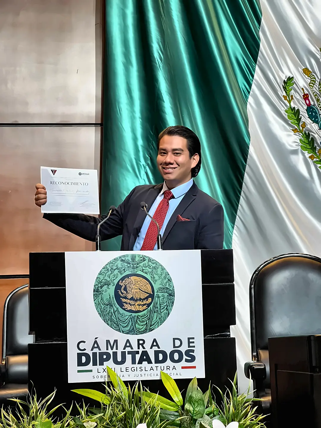 Mauricio Martínez Hernández muestra el reconocimiento en el podio de la Cámara de Diputados